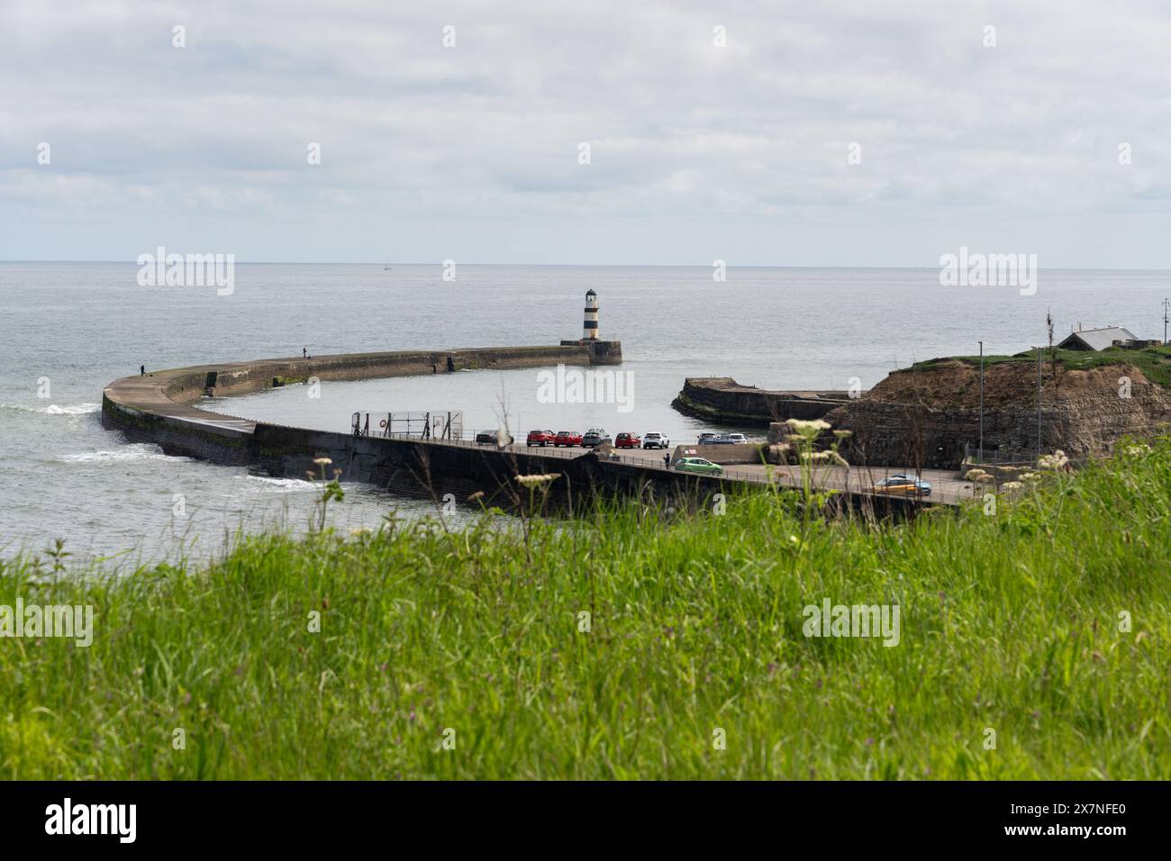 Seaham, Contea di Durham, Regno Unito. Vista sul faro e sulle mura del porto della città. Foto Stock