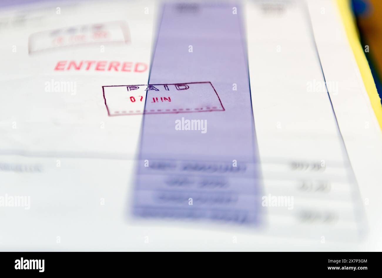 Un concetto di contabilità aziendale con un primo piano di una fattura contrassegnata con le parole inserite e pagate. Foto Stock