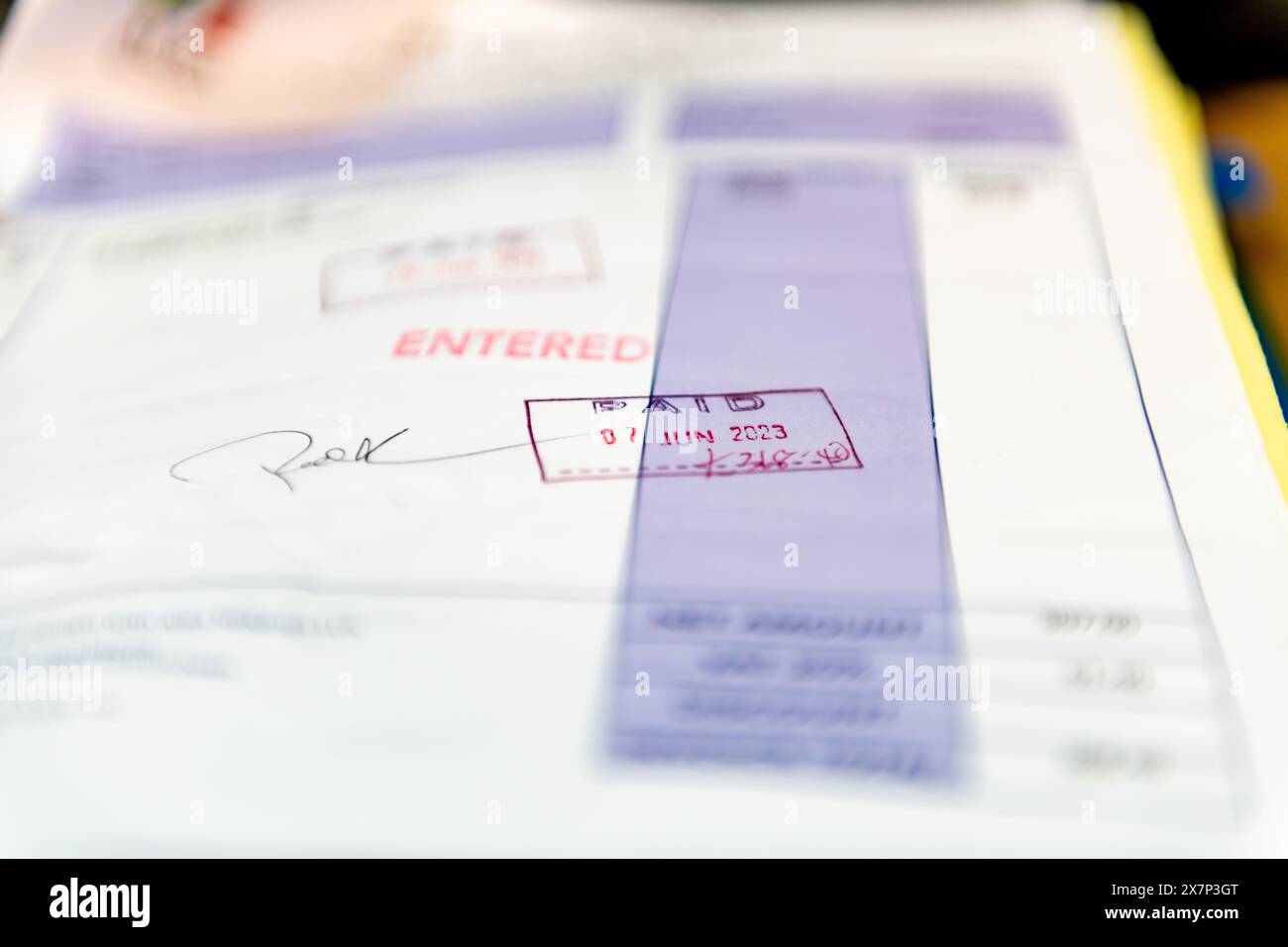 Londra. REGNO UNITO- 05.20.2023. Primo piano di una fattura aziendale timbrata con le parole inserite e pagate. Contabilità aziendale Foto Stock