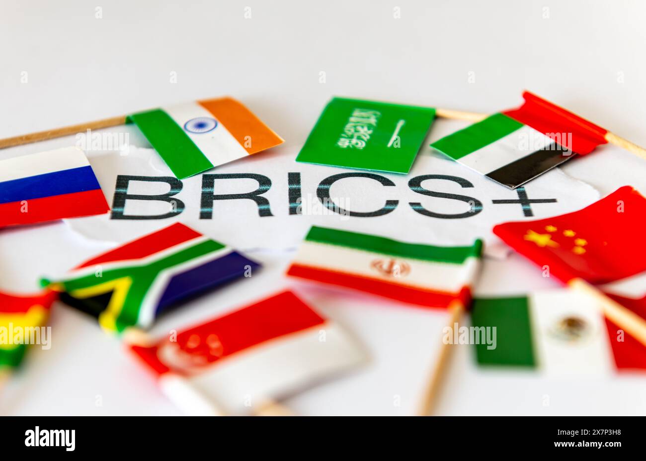 Un concetto BRICS+ con la parola e le bandiere di paese del blocco di paesi isolati in bianco. Foto Stock