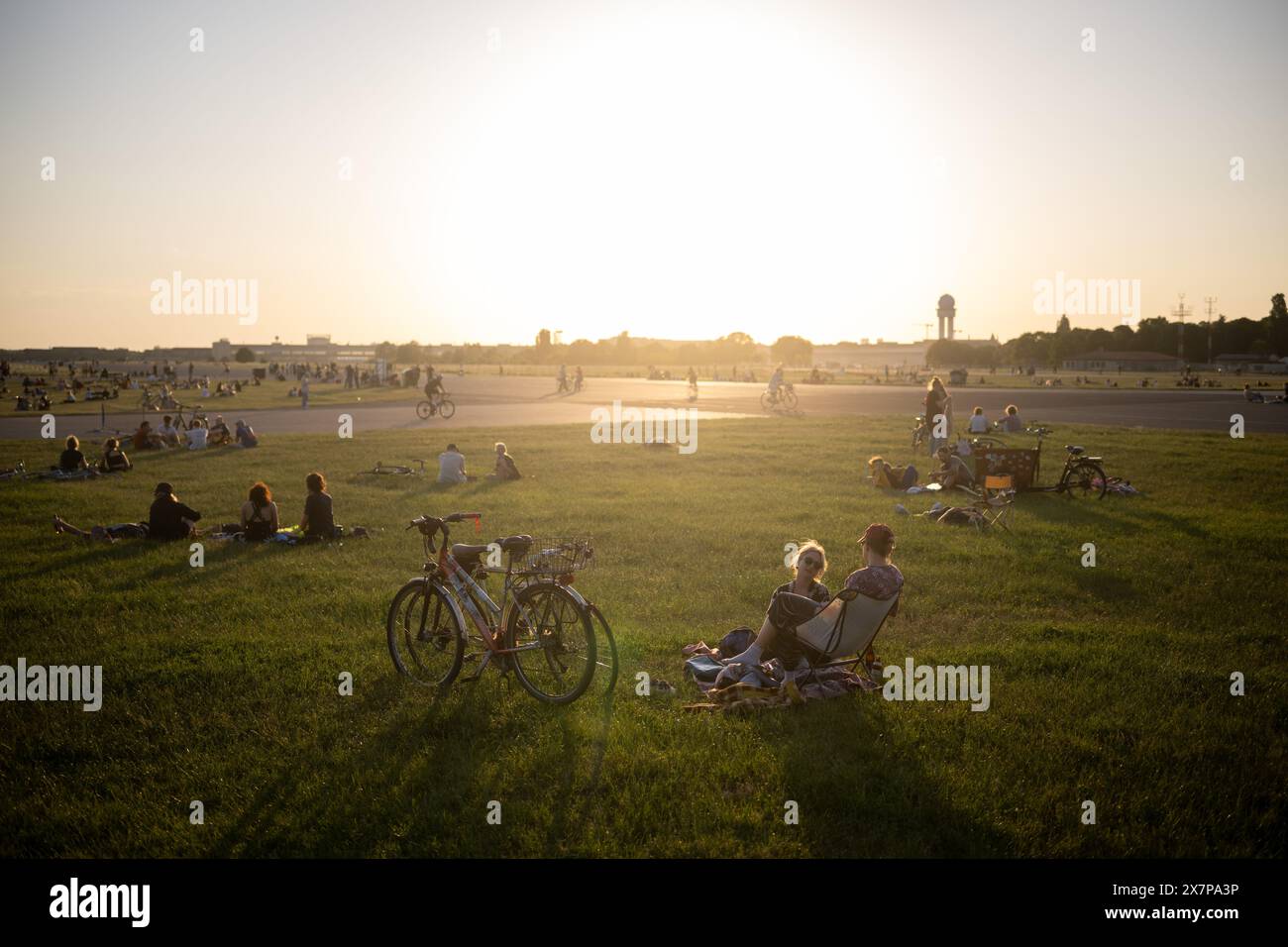 Berlino, Germania. 15 maggio 2024. La gente siede su Tempelhofer Feld. Lo spazio verde potrebbe essere utilizzato per lo sviluppo periferico. Crediti: Sebastian Gollnow/dpa/Alamy Live News Foto Stock