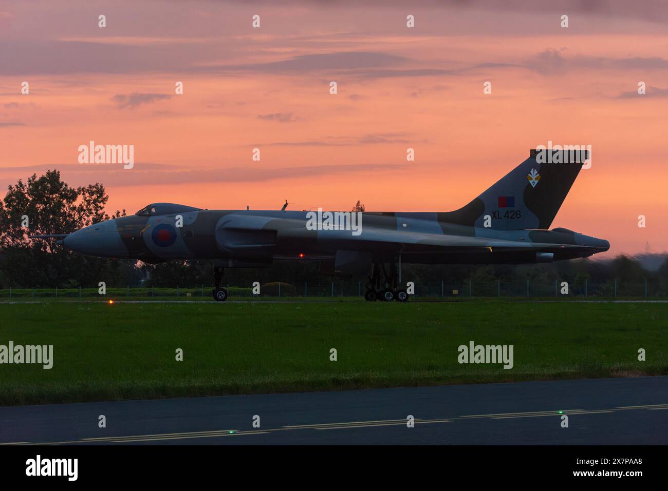 Bombardiere jet d'epoca Avro Vulcan B2 che effettua una corsa in taxi per gli appassionati al tramonto, all'aeroporto di Southend, Essex, Regno Unito. Profilo laterale e cielo al tramonto Foto Stock