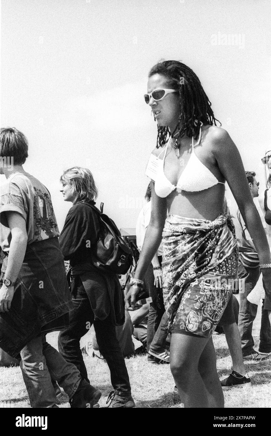 CROWD, HEATWAVE, NME STAGE, GLASTONBURY 95: Una donna in tonalità bianche, bikini bianco e gonna tie-die anni '90 al secondo NME Stage Field e folla al Glastonbury Festival, Pilton Farm, Somerset, Inghilterra, 24 giugno 1995. Nel 1995 il festival ha celebrato il suo 25 ° anniversario. Molte persone hanno lottato con il colpo di calore nel weekend particolarmente caldo. Foto: ROB WATKINS Foto Stock