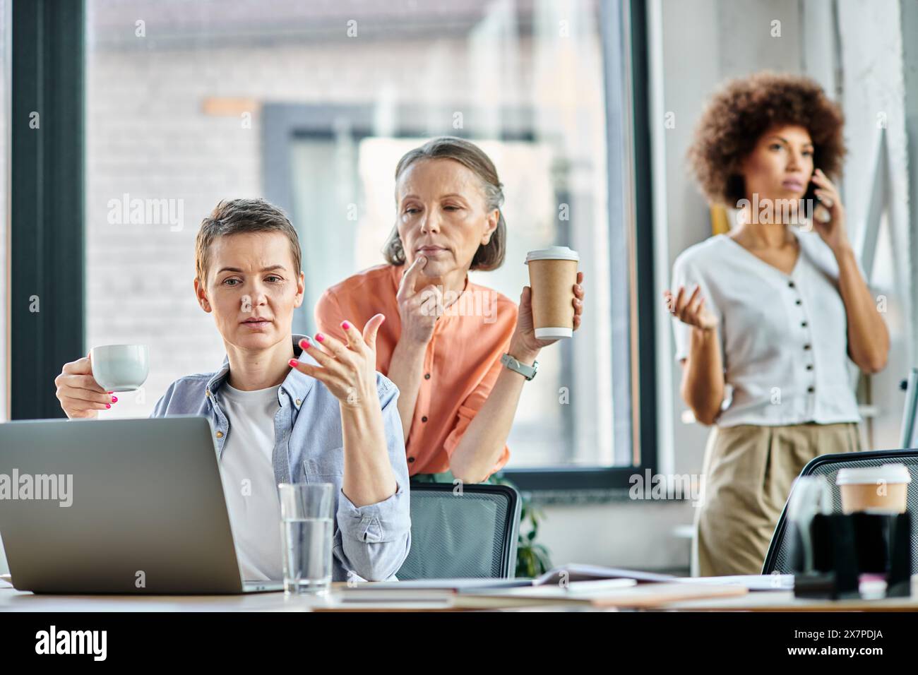 Diversi gruppi di professionisti si sono impegnati in una riunione collaborativa attorno a un tavolo con un notebook. Foto Stock