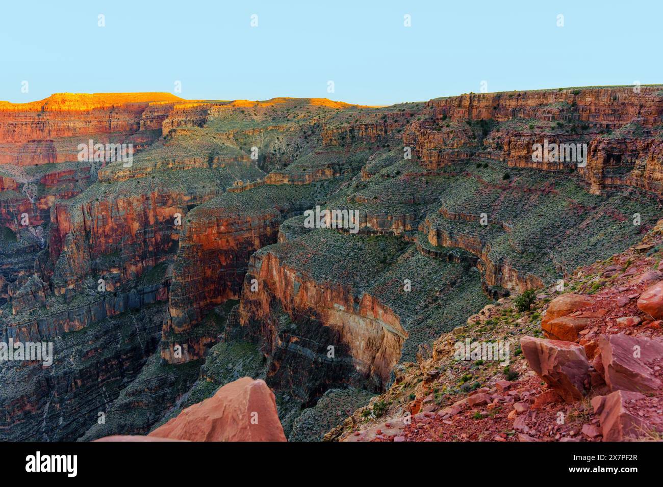 Vista ravvicinata di un vasto canyon con formazioni rocciose a strati che mostrano varie sfumature di rosso, marrone e verde. Foto Stock