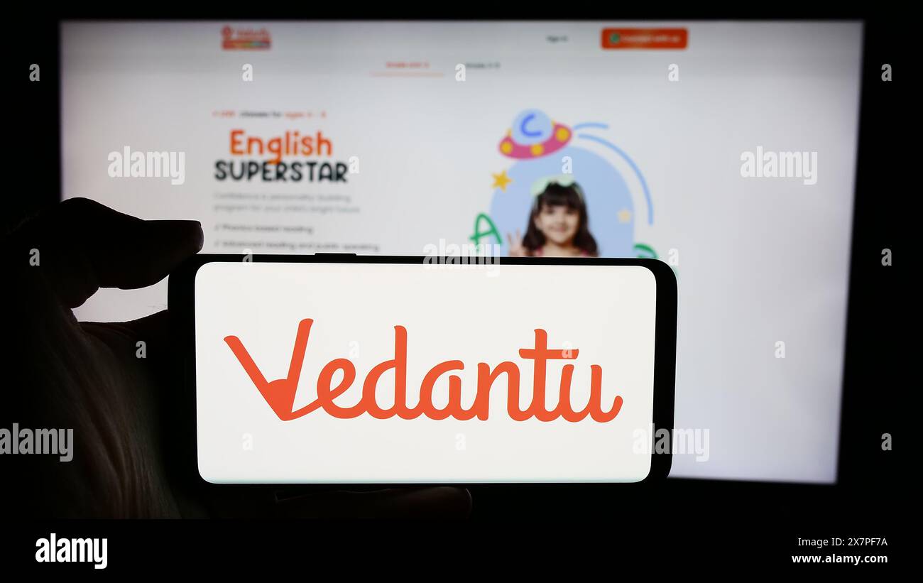 Persona che detiene un cellulare con il logo dell'azienda indiana Vedantu Innovations Pvt. Ltd. Di fronte alla pagina Web. Mettere a fuoco il display del telefono. Foto Stock