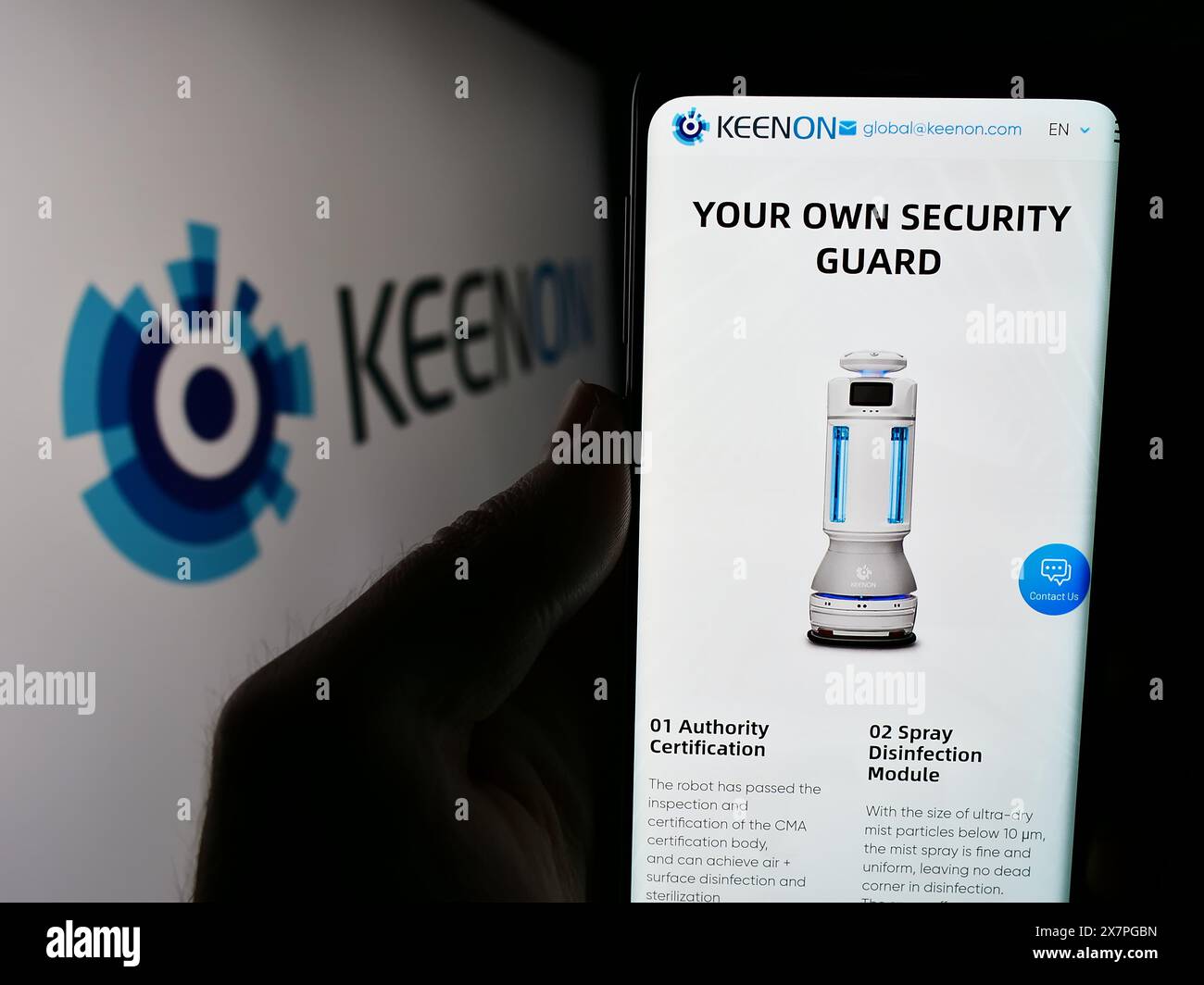 Persona che detiene un cellulare con pagina web dell'azienda cinese di robot di assistenza Keenon Robotics Co. Ltd. Con logo. Messa a fuoco al centro del display del telefono. Foto Stock