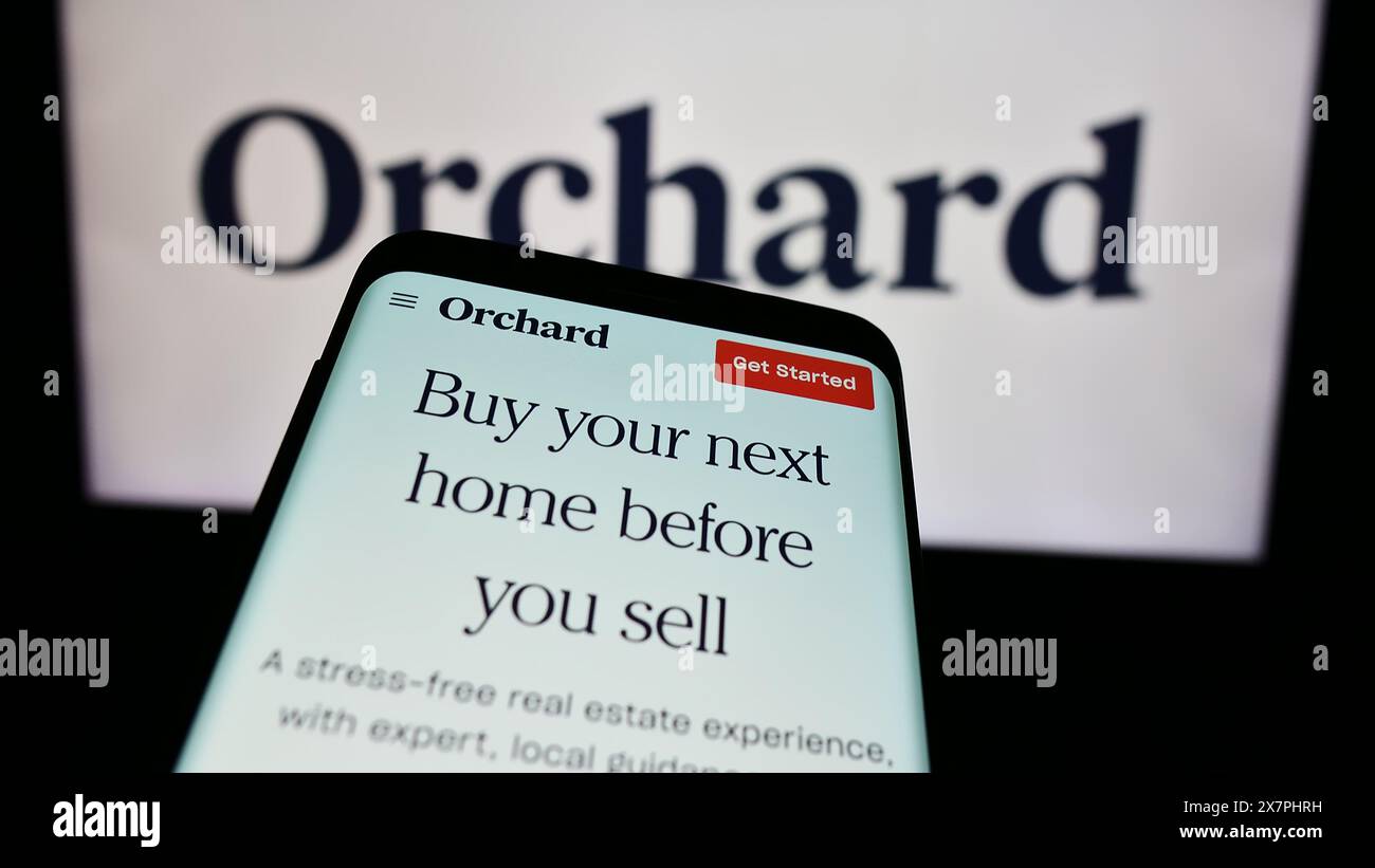 Telefono cellulare con sito web della società statunitense Orchard Technologies Inc. Di fronte al logo. Mettere a fuoco in alto a sinistra sul display del telefono. Foto Stock