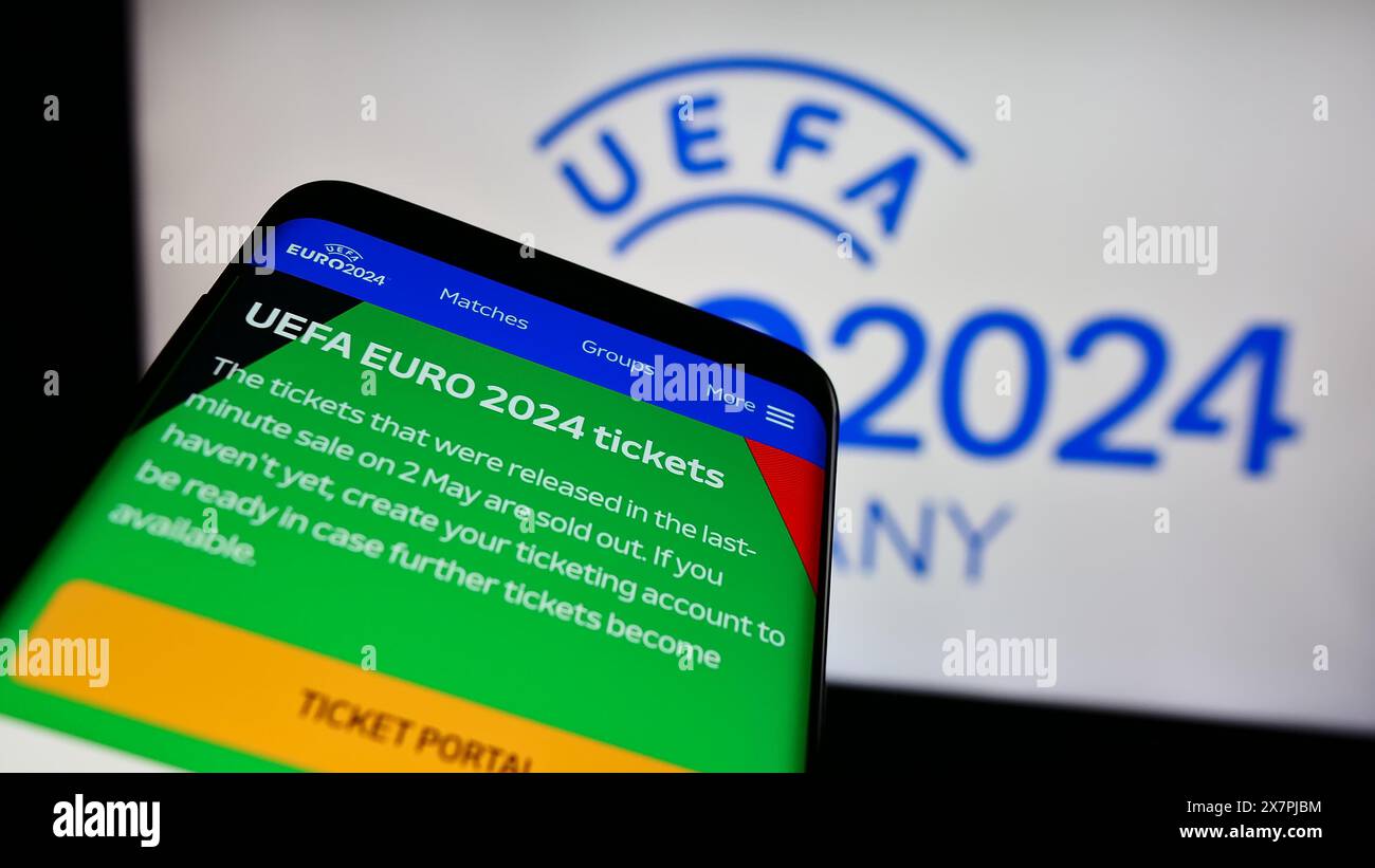 Telefono cellulare con sito web del campionato europeo di calcio UEFA Euro 2024 davanti al logo. Mettere a fuoco in alto a sinistra sul display del telefono. Foto Stock