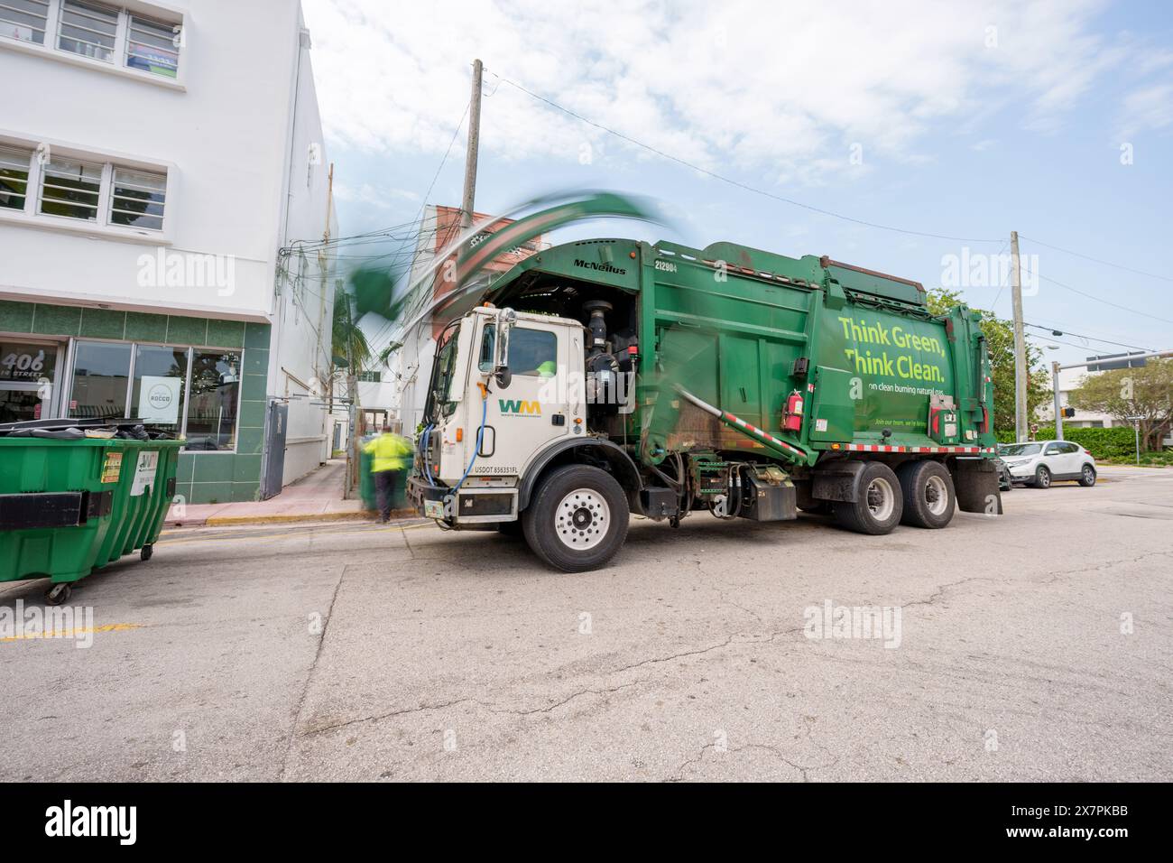 Miami Beach, Florida, Stati Uniti - 20 maggio 2024: Camion della spazzatura WM che scarica un cassonetto. Esposizione lunga che sfoca il movimento della gru Foto Stock