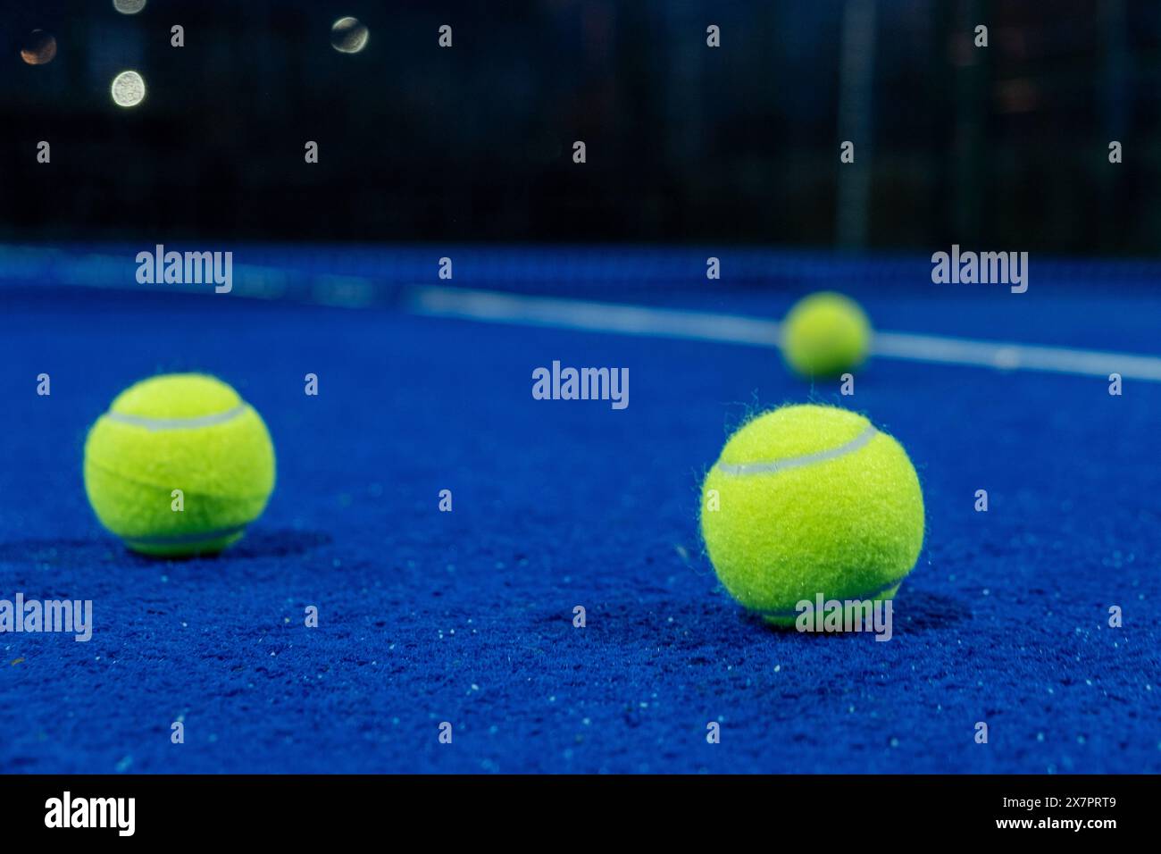 tre palline sulla superficie di un campo da paddle tennis di notte, sport con racchette Foto Stock