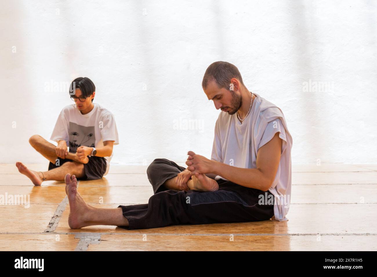 I partecipanti in uno spazio sereno si preparano per una cerimonia di danza olistica, stretching e meditazione Foto Stock