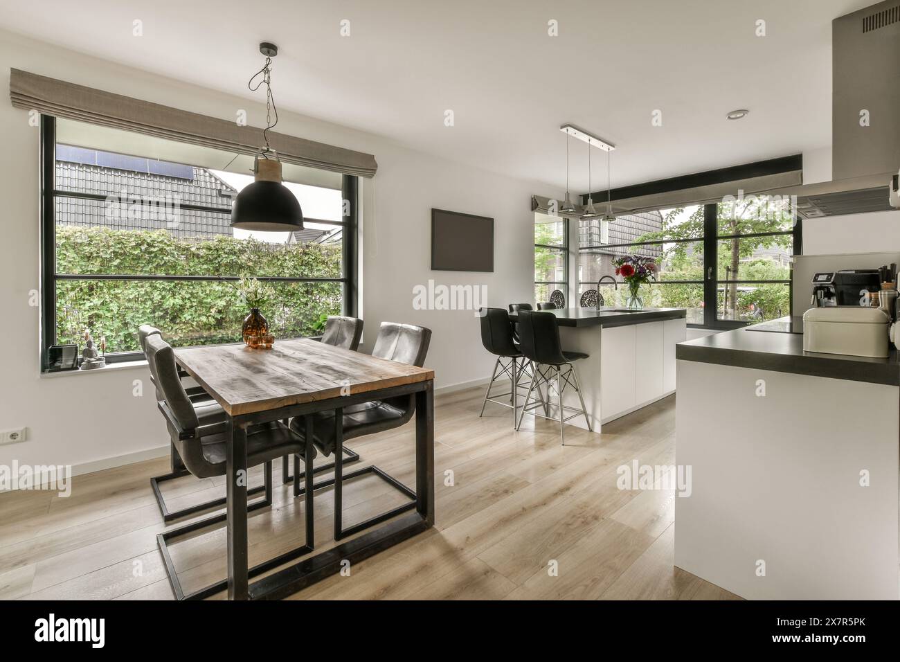 Interni spaziosi ed eleganti a Madrid, con un'elegante zona pranzo con grandi finestre e un'accogliente cucina Foto Stock