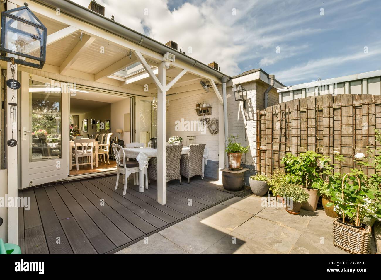 Questa invitante immagine mostra un patio sul cortile splendidamente disposto a Schaarweg, Amsterdam, con una rilassante area salotto, lussureggianti piante in vaso, un Foto Stock