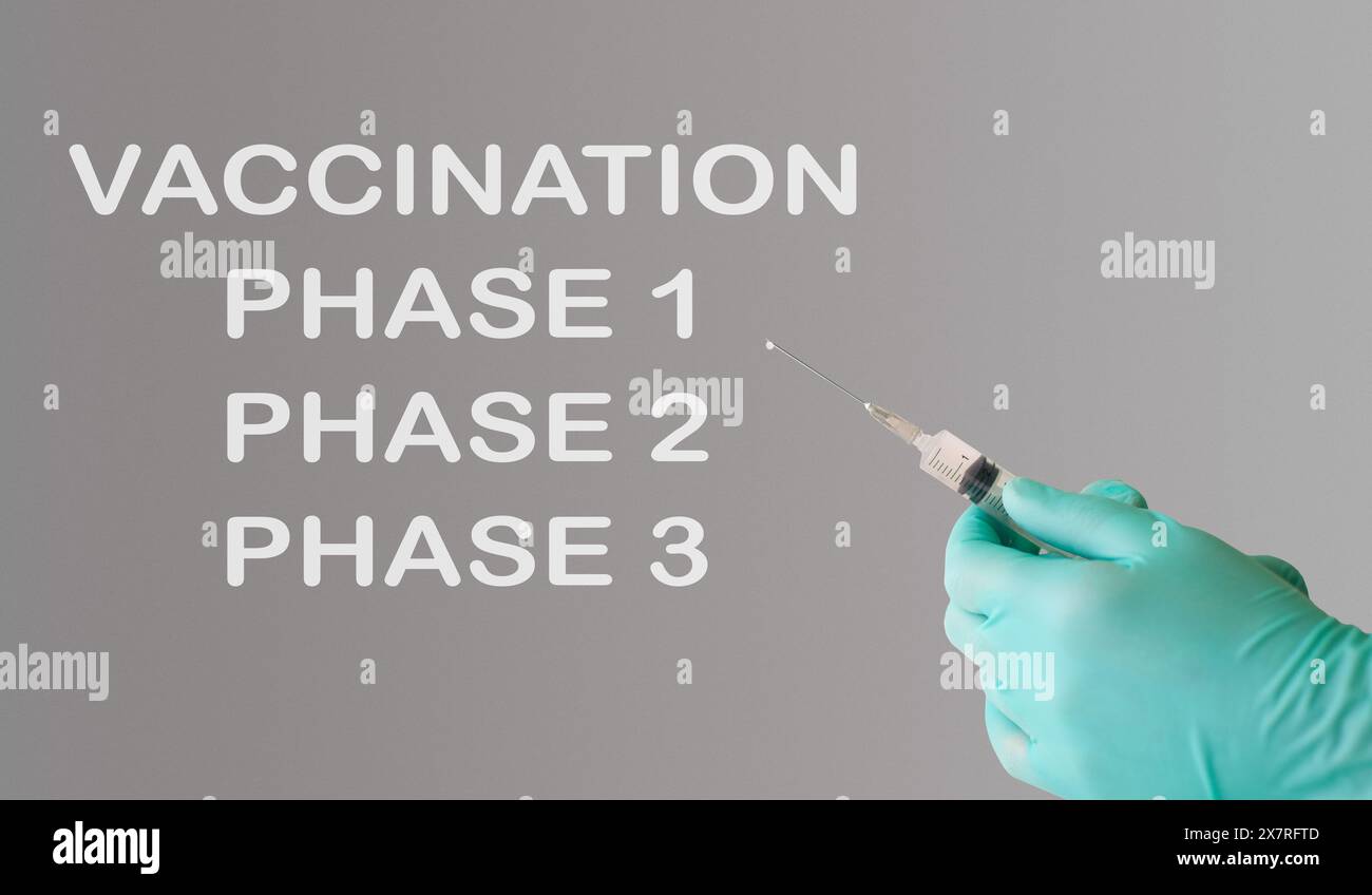 Una persona che tiene in mano una siringa con la parola vaccinazione scritta sul muro dietro di loro. L'immagine trasmette l'importanza delle vaccinazioni e il ruolo di Foto Stock