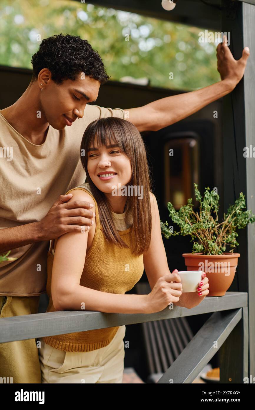 Un uomo e una donna stanno insieme su un balcone, godendosi un momento romantico. Foto Stock