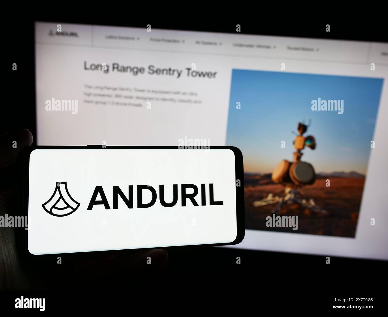 Persona che detiene lo smartphone con il logo della società statunitense di tecnologia per la difesa Anduril Industries Inc. Davanti al sito Web. Mettere a fuoco il display del telefono. Foto Stock