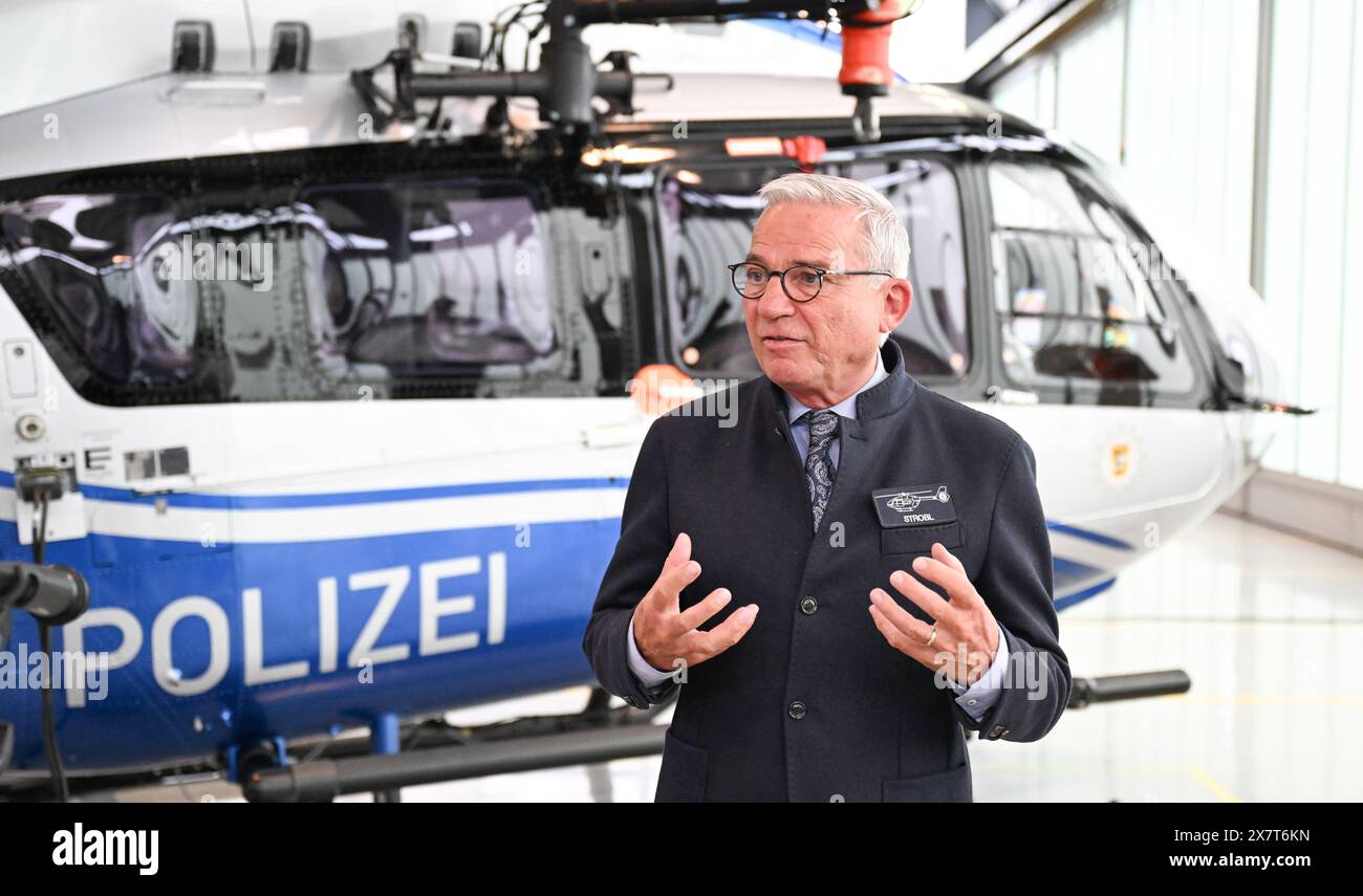 Filderstadt, Germania. 21 maggio 2024. Thomas Strobl (CDU), ministro degli interni del Baden-Württemberg, parla all'aeroporto di Stoccarda presso lo squadrone di elicotteri della polizia di fronte a un elicottero della polizia che è stato convertito in rotori a cinque pale. Lo squadrone di elicotteri della polizia del Baden-Württemberg ha convertito l'intera flotta da rotori a quattro pale a cinque pale. I rotori a cinque pale consentono un maggiore carico utile, forniscono caratteristiche di volo più stabili e causano meno rumore degli aeromobili. Crediti: Bernd Weißbrod/dpa/Alamy Live News Foto Stock