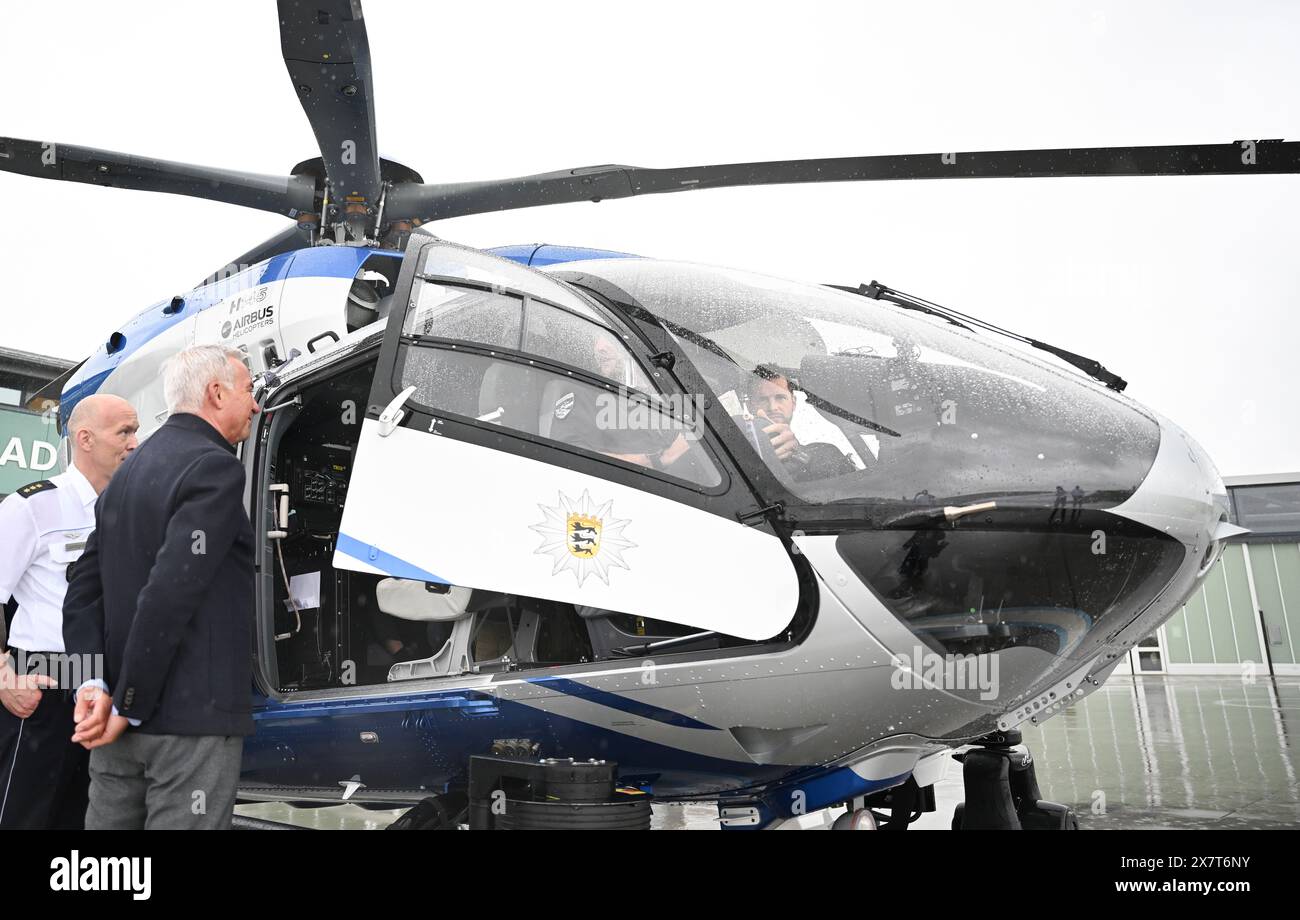 Filderstadt, Germania. 21 maggio 2024. Thomas Strobl (CDU, 2vl), ministro degli interni del Baden-Württemberg, guarda un elicottero della polizia che è stato convertito in rotori a cinque pale all'aeroporto di Stoccarda. Lo squadrone di elicotteri della polizia del Baden-Württemberg ha convertito l'intera flotta da rotori a quattro pale a cinque pale. I rotori a cinque pale consentono un maggiore carico utile, forniscono caratteristiche di volo più stabili e causano meno rumore degli aeromobili. Crediti: Bernd Weißbrod/dpa/Alamy Live News Foto Stock