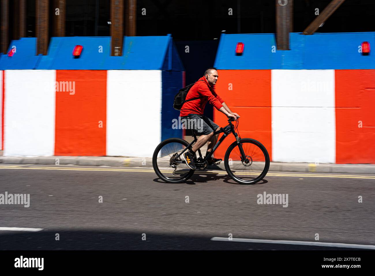 Il ciclista che indossava pantaloncini a pedali ha superato una struttura temporanea a Oxford Street, nel Regno Unito Foto Stock