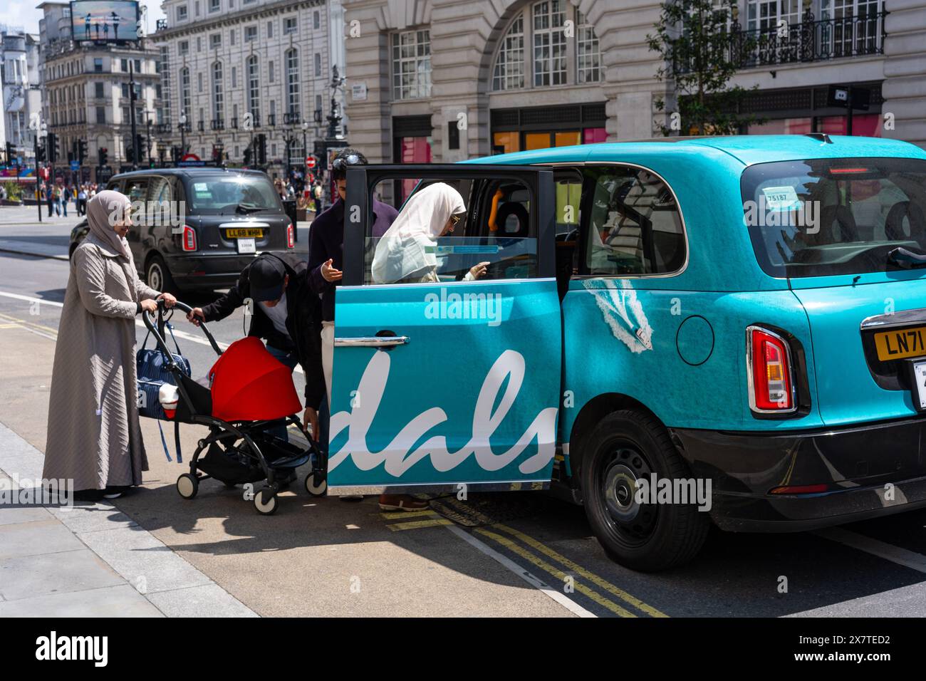 La famiglia entra in un taxi di Londra con la livrea per l'attività del Sandals Resort. Girato su Regent Street, Londra Regno Unito Foto Stock
