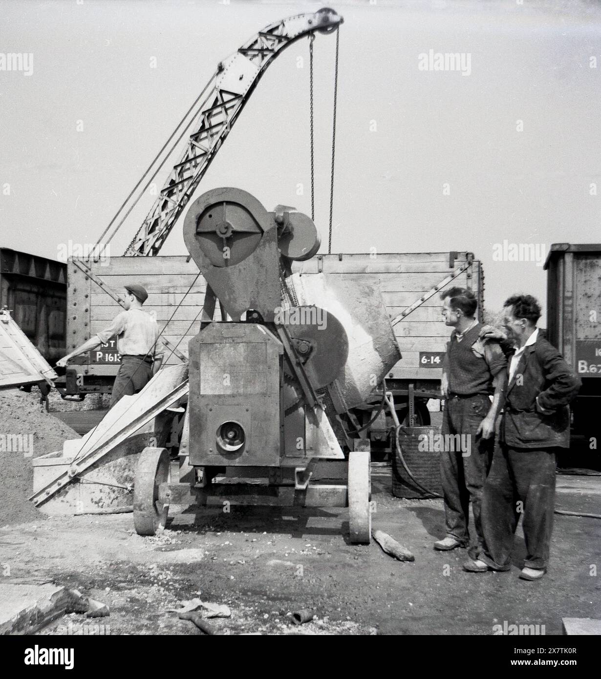 Anni '1950, storico, cantiere edile, lavoratori in piedi accanto a un cementificio dell'epoca, Inghilterra, Regno Unito. Foto Stock