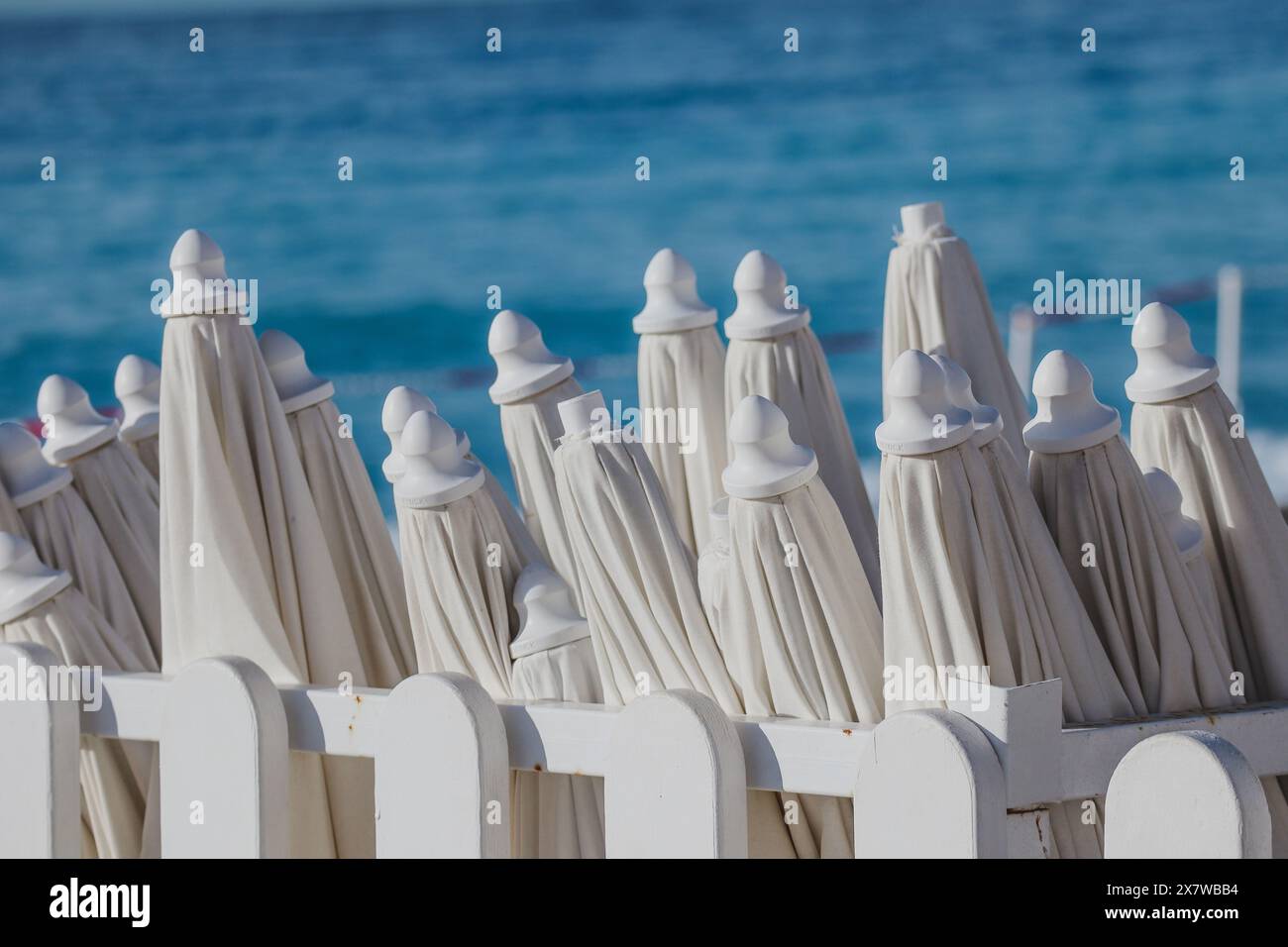 Ombrelloni chiusi sulla spiaggia al mattino, alla fine della stagione Foto Stock