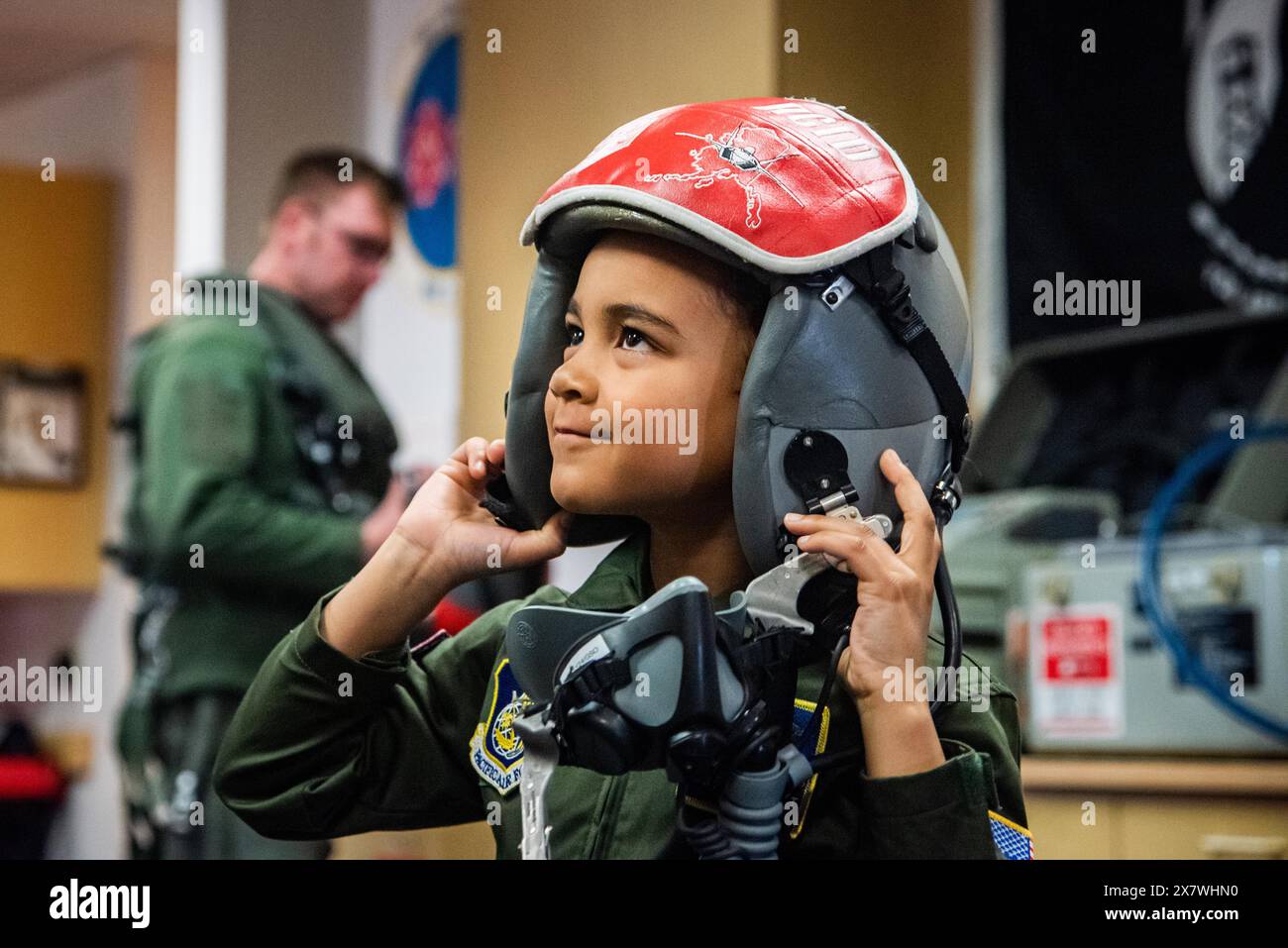 Jayce Rodgers prova l'elmetto di un pilota di caccia durante una visita al 90th Fighter Squadron presso Joint base Elmendorf-Richardson, Alaska, il 29 aprile 2024. Jayce insieme alla sua famiglia visitò il 90th Fighter Squadron per saperne di più su dove lavorano i suoi genitori e vedere un F-22 Raptor da vicino come parte di Month of the Military Child. SOLO PER USO EDITORIALE! Non per USO commerciale! Foto Stock