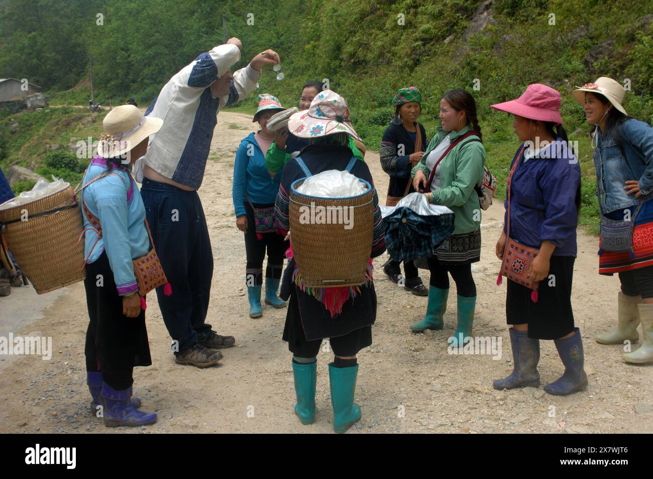 Un tizio caucasico viene molestato da donne locali per comprare souvenir, Cat Cat Village, Sapa, Lao Cai, Vietnam. Foto Stock