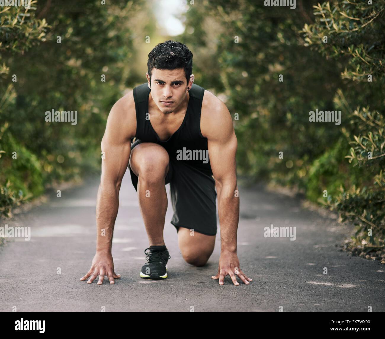 Uomo, corridore o inizio di corsa nel parco, nella natura o sul marciapiede per esercizi all'aperto, gare o allenamenti di fitness. Uomo, ragazzo o atleta indiano pronto Foto Stock