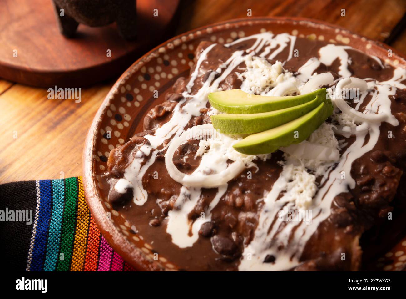 Enfrijoladas. Tortillas di mais immerse in salsa di fagioli, ricoperte di crema e formaggio, possono essere ricoperte o ripiene di carne di pollo, formaggio o un po' di olio Foto Stock
