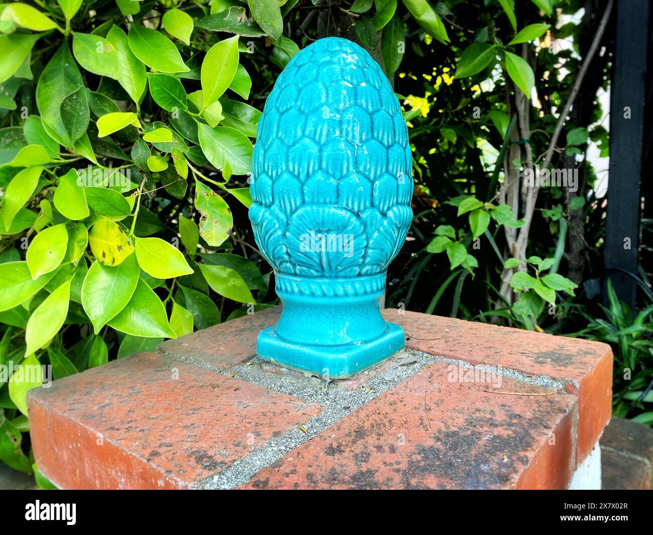 Un cono di pino ceramico blu all'ingresso di una casa. Comuni in Sicilia, i coni di pino ceramico rappresentano salute e prosperità. Foto Stock