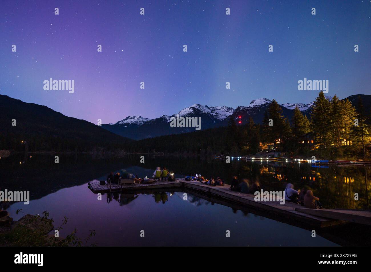 Folle di persone osservano l'aurora boreale brillantemente sul lago Green, vicino a Whistler, British Columbia, Canada. Una tempesta solare quella sera ha causato una b insolitamente Foto Stock