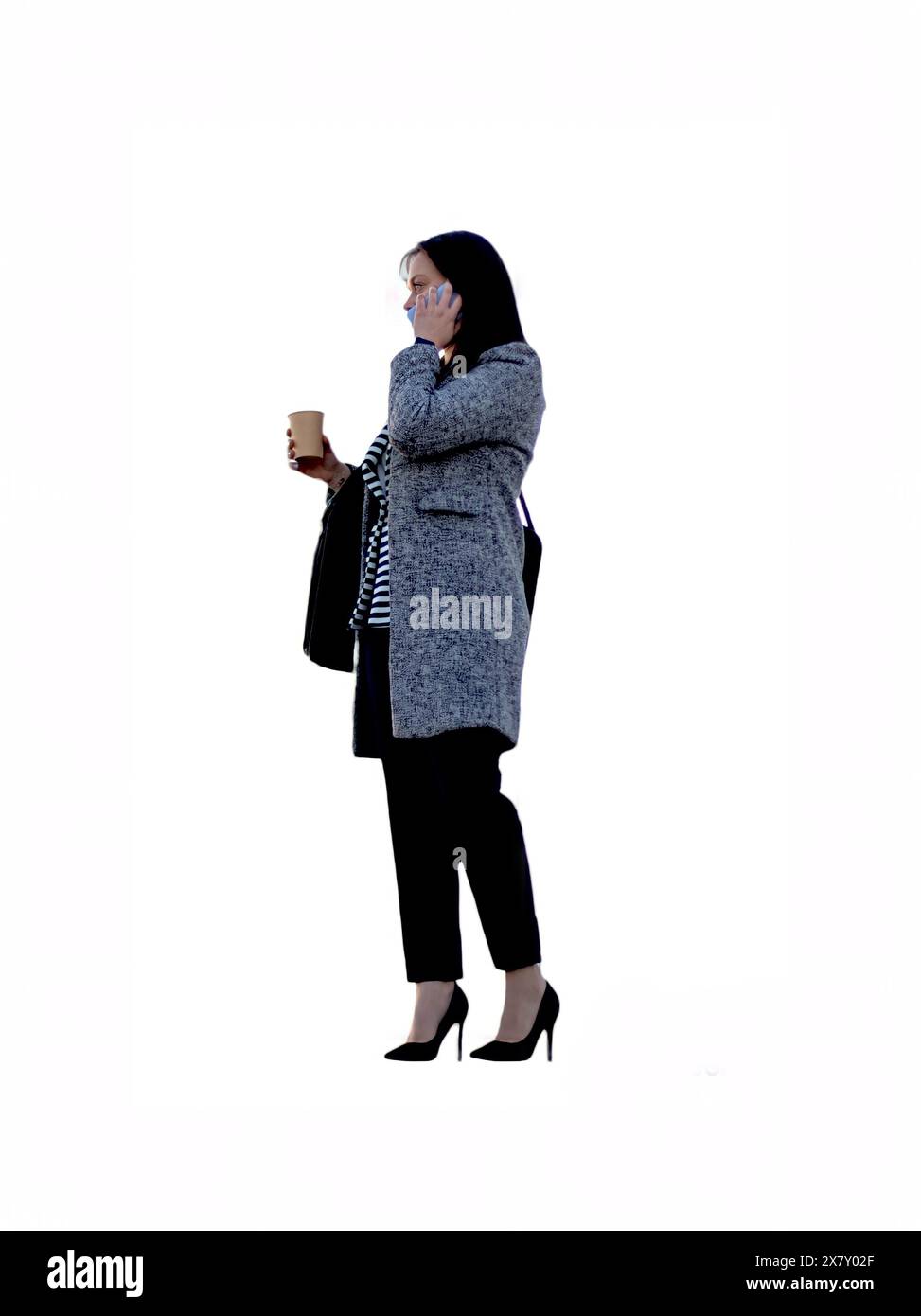 Ritratto verticale di una bella giovane donna d'affari con caffè che parla per telefono su sfondo bianco Foto Stock