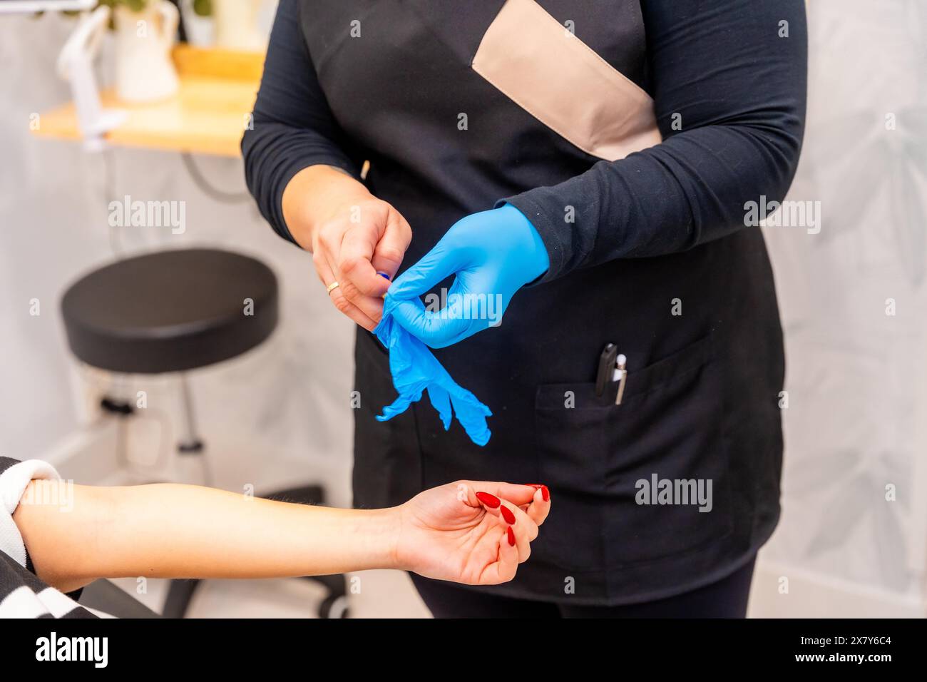 Esperienza nella preparazione di prelevare un campione di sangue da una donna per un trattamento di calvizie sostitutivo Foto Stock