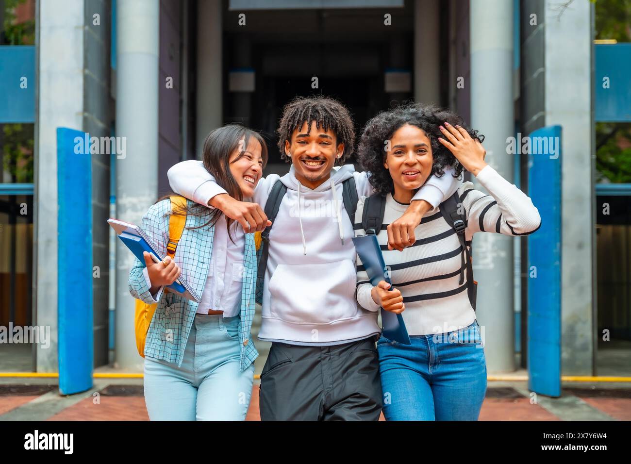 Ritratto di tre amici multietnici dell'università che sorridono insieme alla fotocamera con un look felice Foto Stock