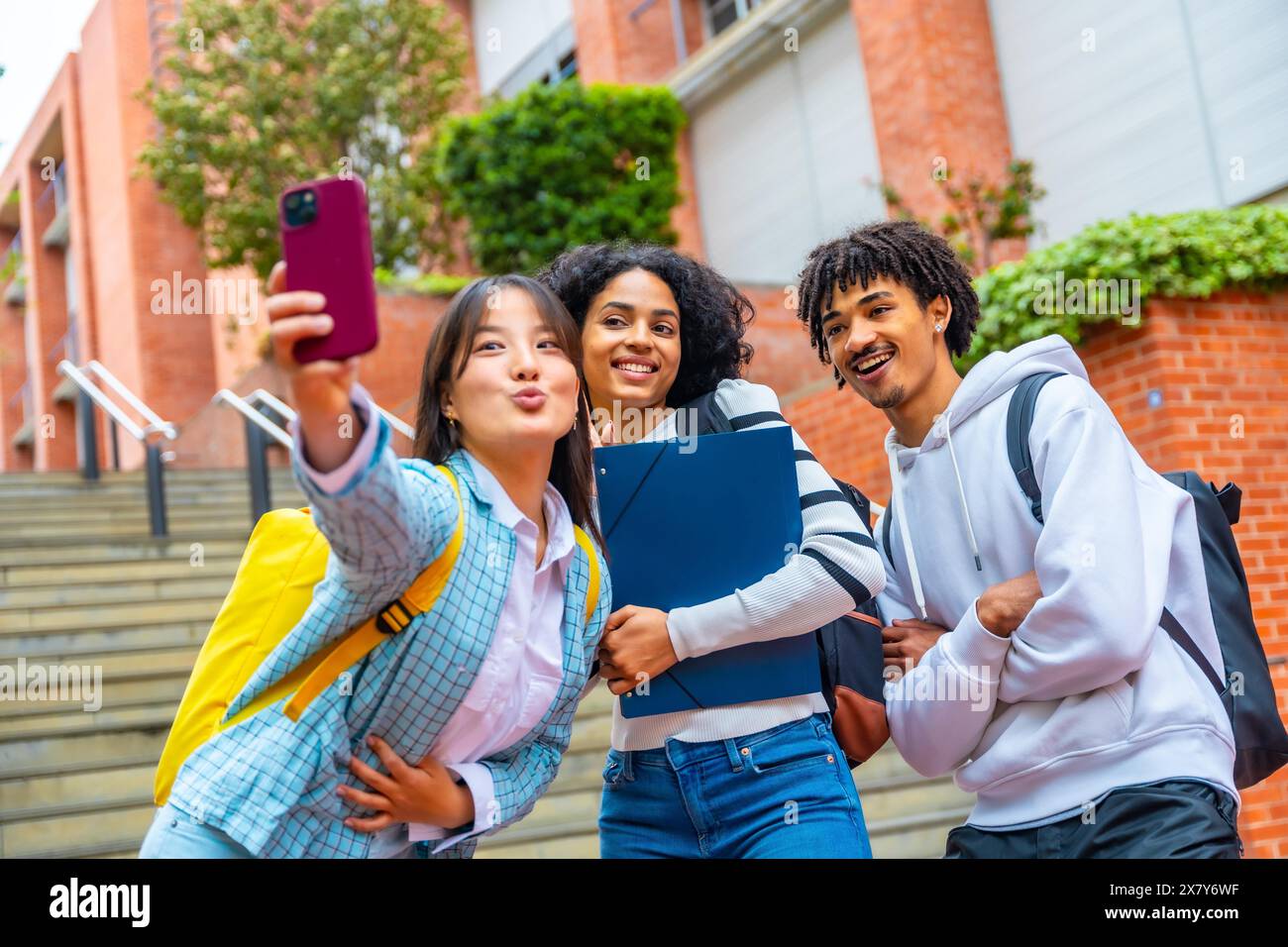 Tre amici multietnici si fanno un selfie nel campus dell'università Foto Stock