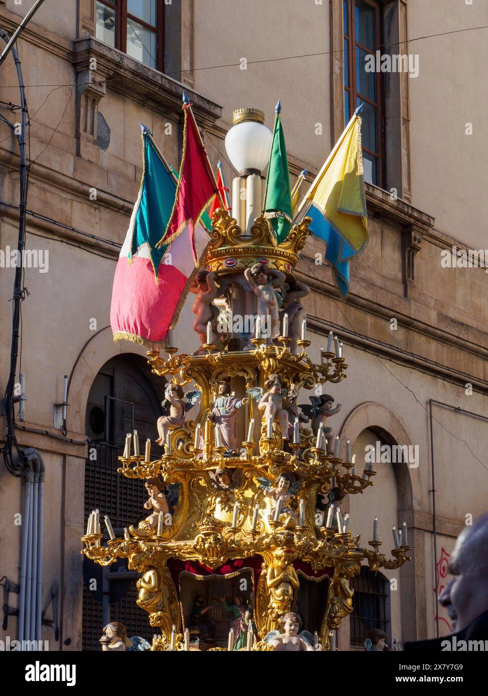 Un'alta struttura dorata ornata con bandiere multiple, esposta in una strada durante il giorno in un'area urbana, Catania, italia, 3 febbraio 2024, 3 giorni f Foto Stock