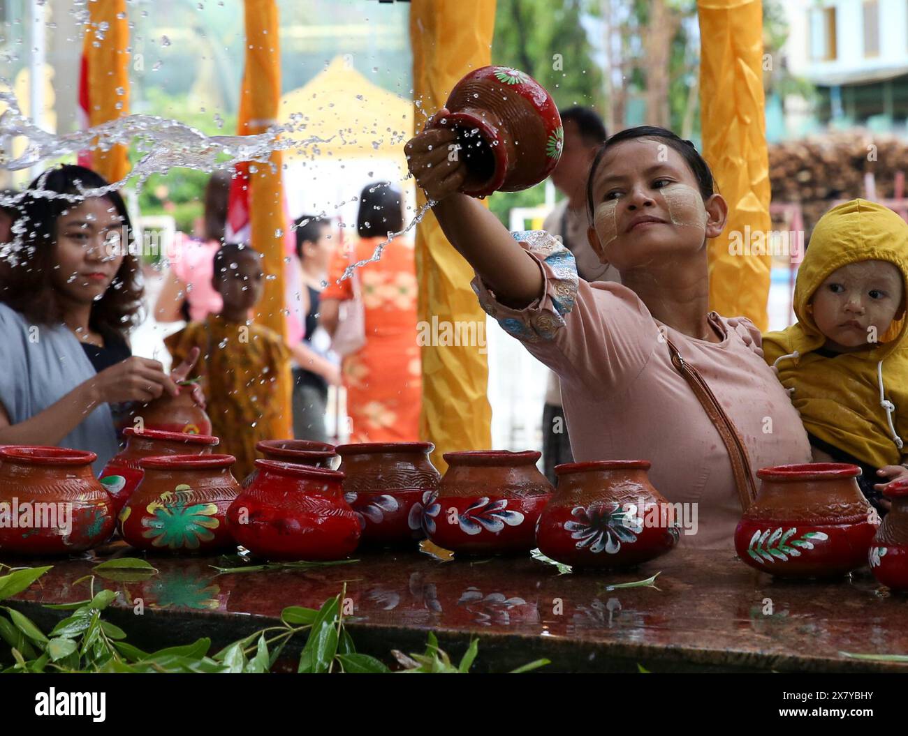 Yangon, Myanmar. 22 maggio 2024. Una donna bagna un albero di Bodhi nel giorno della luna di miele di Kason presso la Pagoda di Botahtaung a Yangon, Myanmar, 22 maggio 2024. Crediti: Myo Kyaw Soe/Xinhua/Alamy Live News Foto Stock