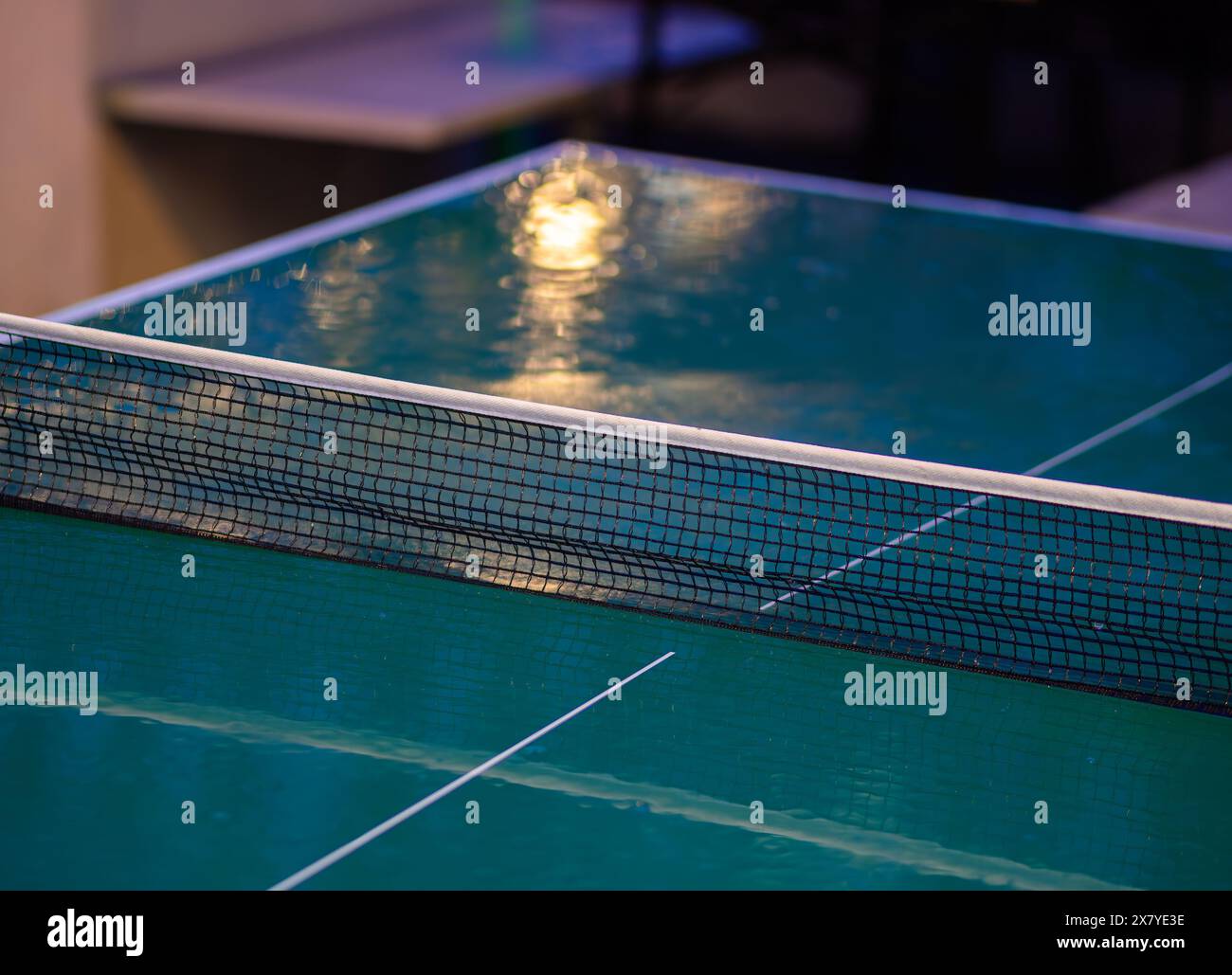 Zurigo, Svizzera - 16 maggio 2024: Primo piano di un tavolo da ping pong verde bagnato con strisce bianche e rete a rete in uno spazio ricreativo all'aperto, ra Foto Stock