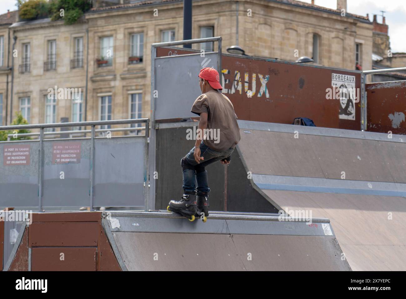 Persone allo skatepark all'aperto, pattinaggio e trucchi sulle rampe Foto Stock