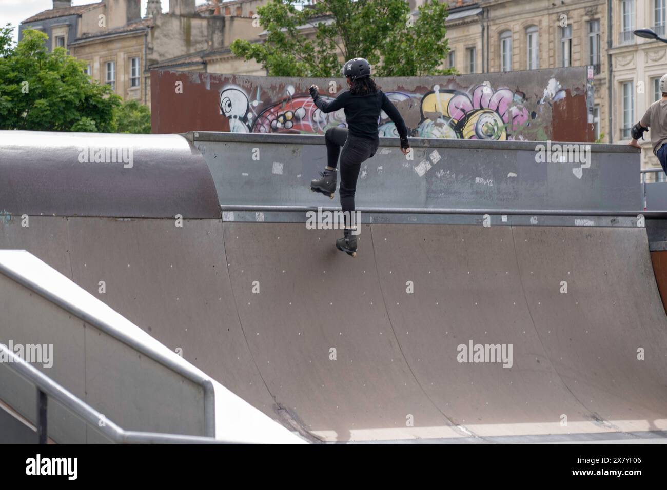 Persone allo skatepark all'aperto, pattinaggio e trucchi sulle rampe Foto Stock