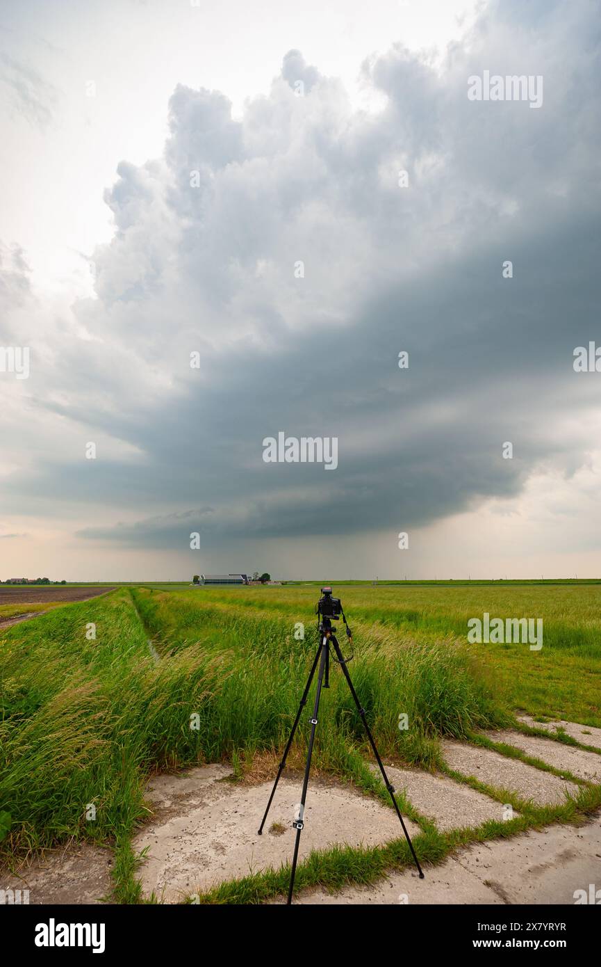 Una fotocamera con fulmine è posizionata vicino a una maestosa tempesta di supercell durante un inseguimento di tempesta sulle grandi Pianure Foto Stock