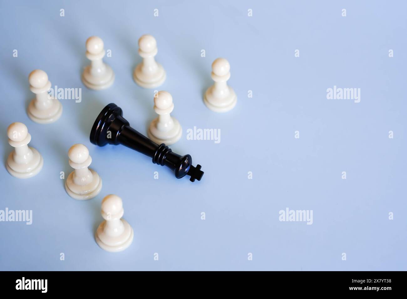 diverse pedine di scacchi circondano un re degli scacchi sconfitto Foto Stock