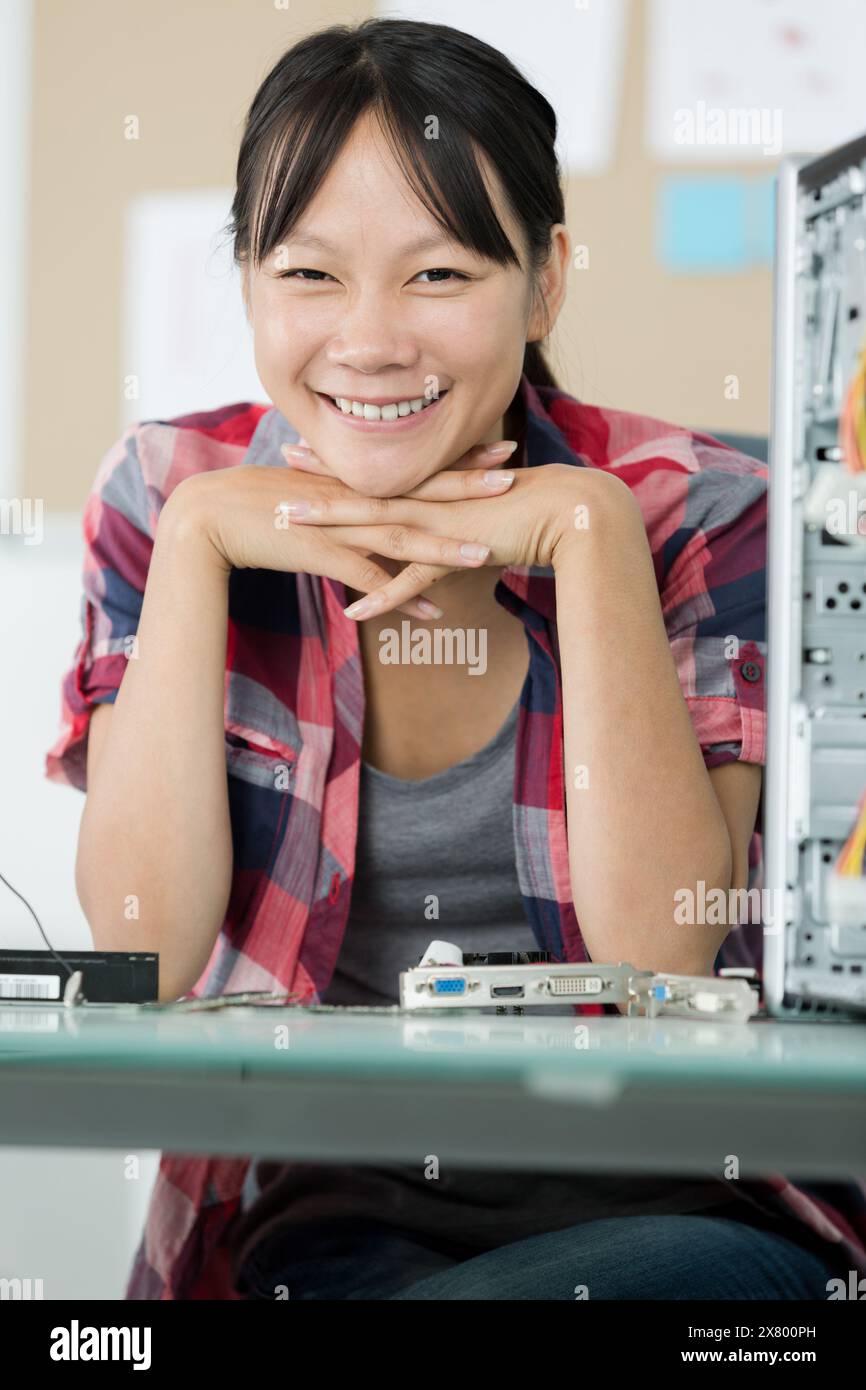 felice tecnico femmina che fissa il computer Foto Stock