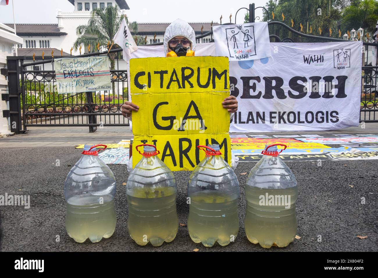 22 maggio 2024, Bandung, Giava Occidentale, Indonesia: Gli attivisti del Forum Indonesiano per l'ambiente (WALHI) hanno un cartello che dice che Citarum non è profumato e di fronte ad esso si trova un campione d'acqua del fiume Citarum che era ancora inquinato durante la protesta del fiume Citarum a Bandung. L'azione ha respinto l'estensione dell'attuazione del programma Citarum Harum perché si è ritenuto che non ci sarebbe stato alcun cambiamento a causa della mancanza di partecipazione della comunità sulle rive del fiume e ha esortato il governo ad assumere immediatamente una posizione ferma per fermare tutte le forme di danno arrecato dagli autori di was Foto Stock