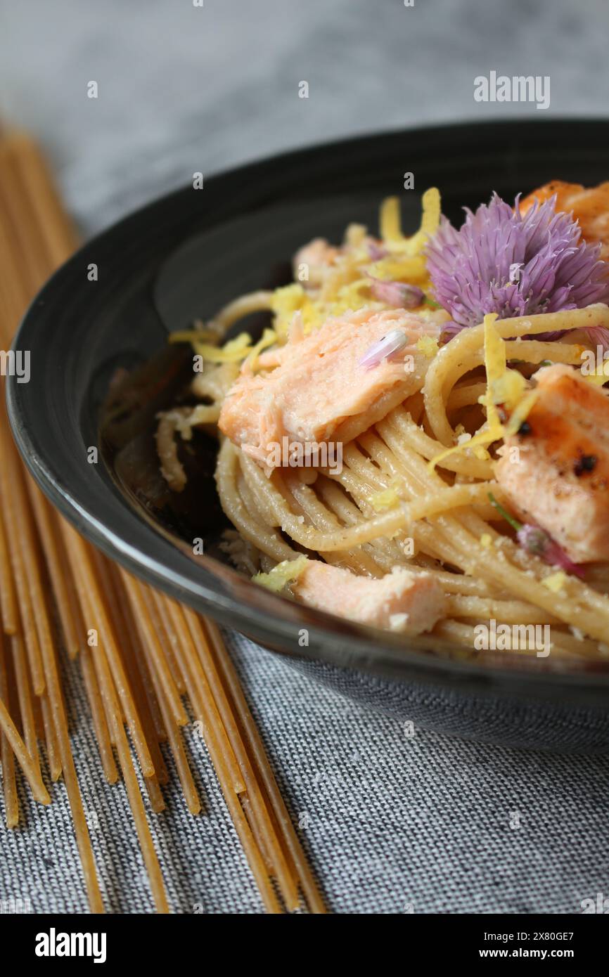 Pasta al limone con salmone e fiori commestibili Foto Stock