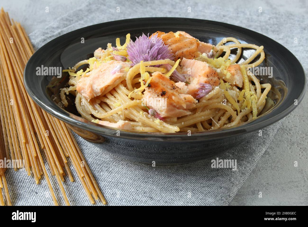 Pasta al limone con salmone e fiori commestibili Foto Stock