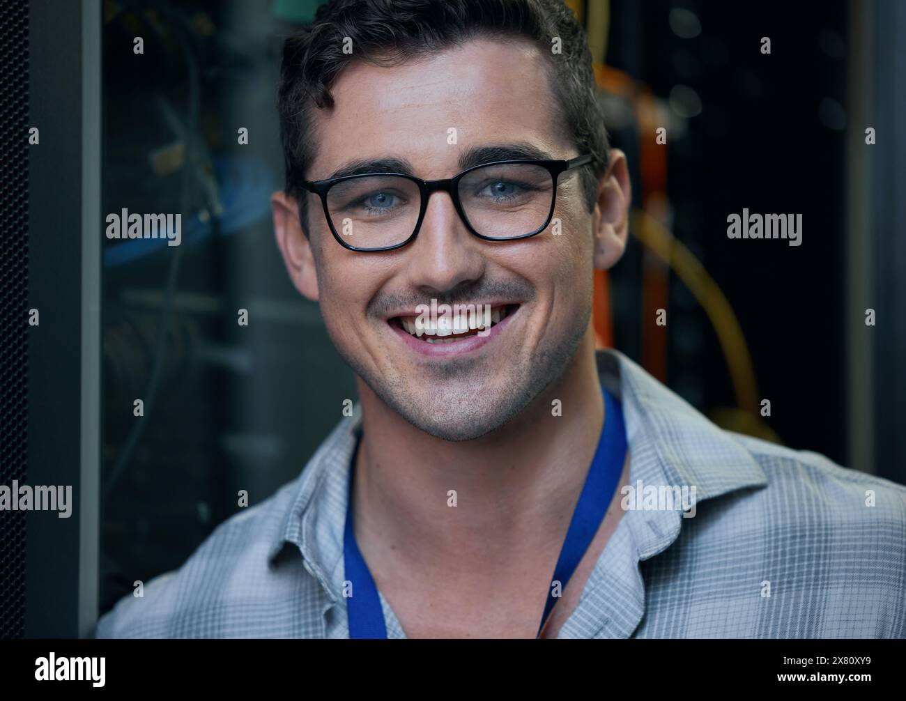 Ritratto, sorriso e supporto con un ingegnere informatico nella sala server per la manutenzione dell'infrastruttura o del mainframe. Sicurezza informatica, database e rete Foto Stock