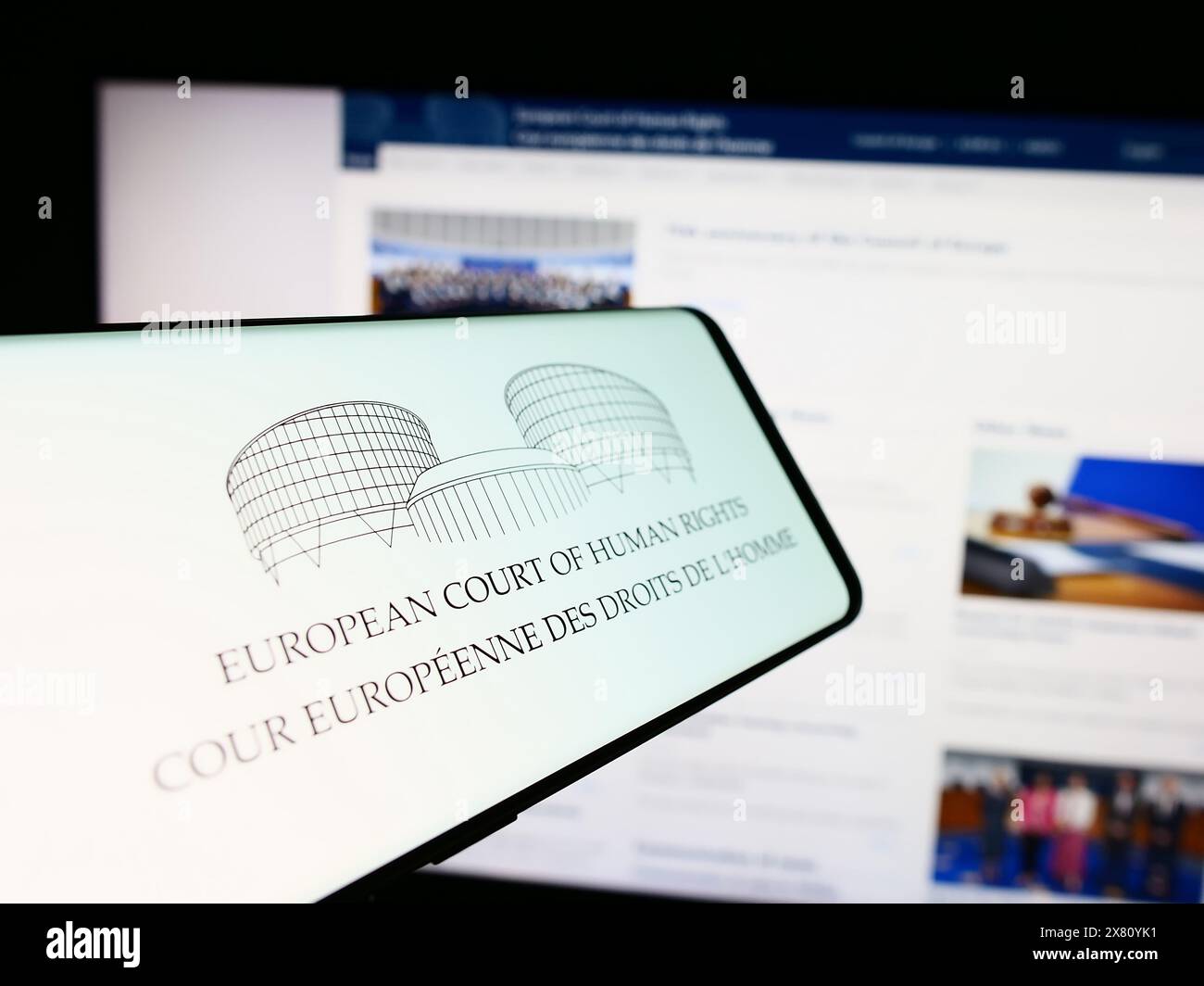 Telefono cellulare con logo del tribunale internazionale Corte europea dei diritti dell'uomo (CEDU) davanti al sito web. Messa a fuoco al centro del display del telefono. Foto Stock